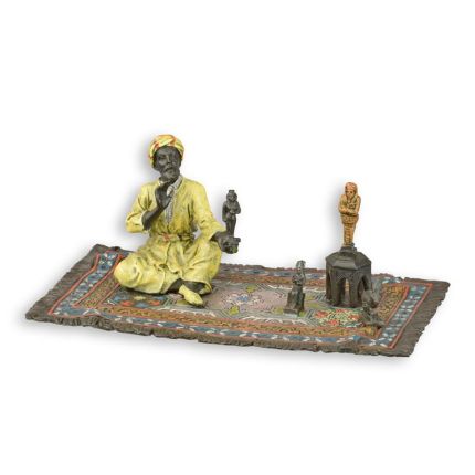 A BRONZE SCULPTURE OF AN ORIENTAL FIGURINE SELLER