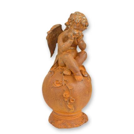 Gusseisenfigur Putte, rostfarben, A RUSTY CAST IRON FIGURINE OF A PUTTO SITTING ON BALL